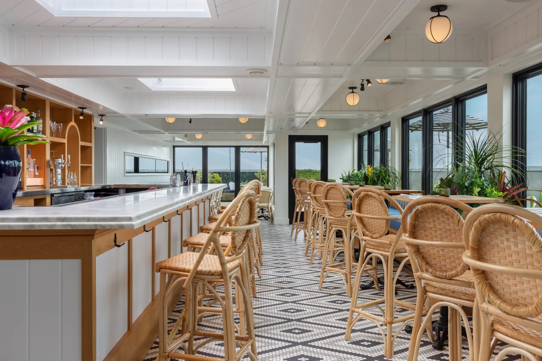 Long marble bar and rattan chairs in the indoor lounge