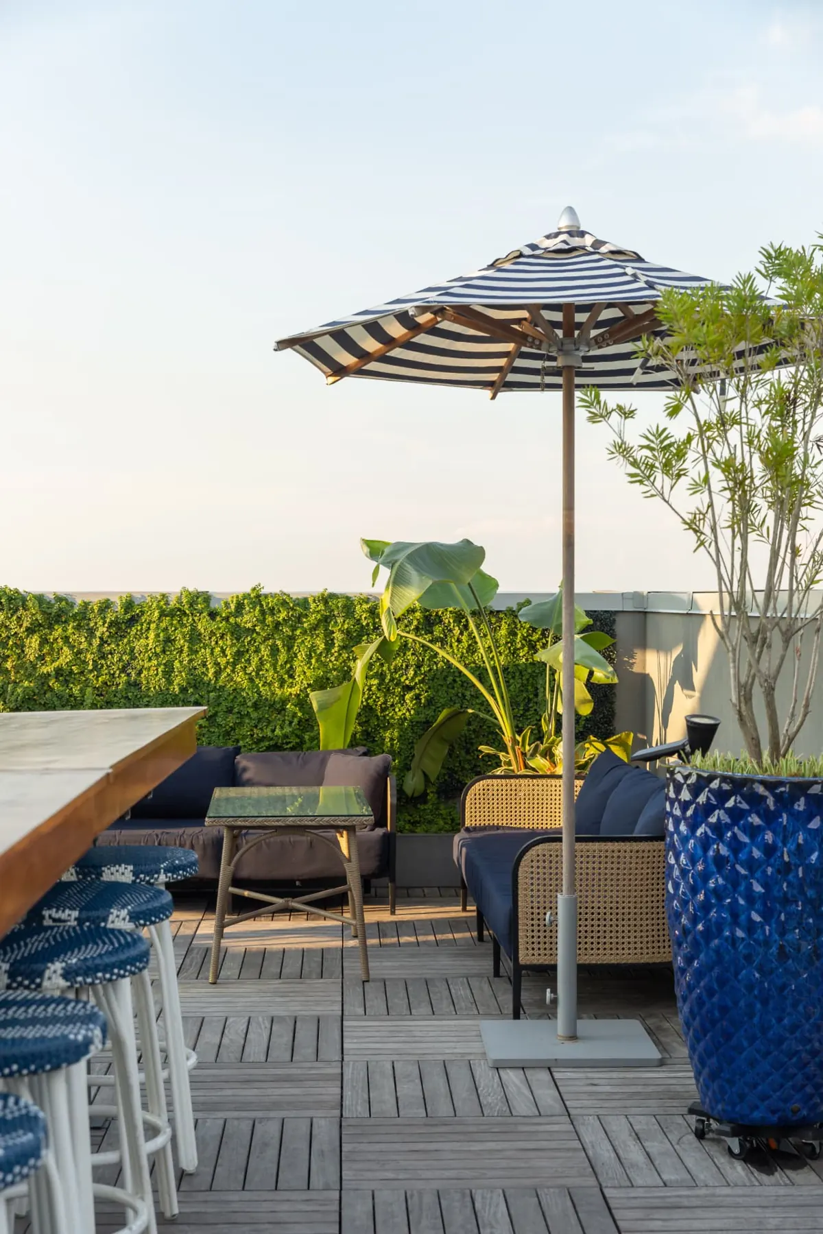 Rooftop lounge seating under a striped umbrella