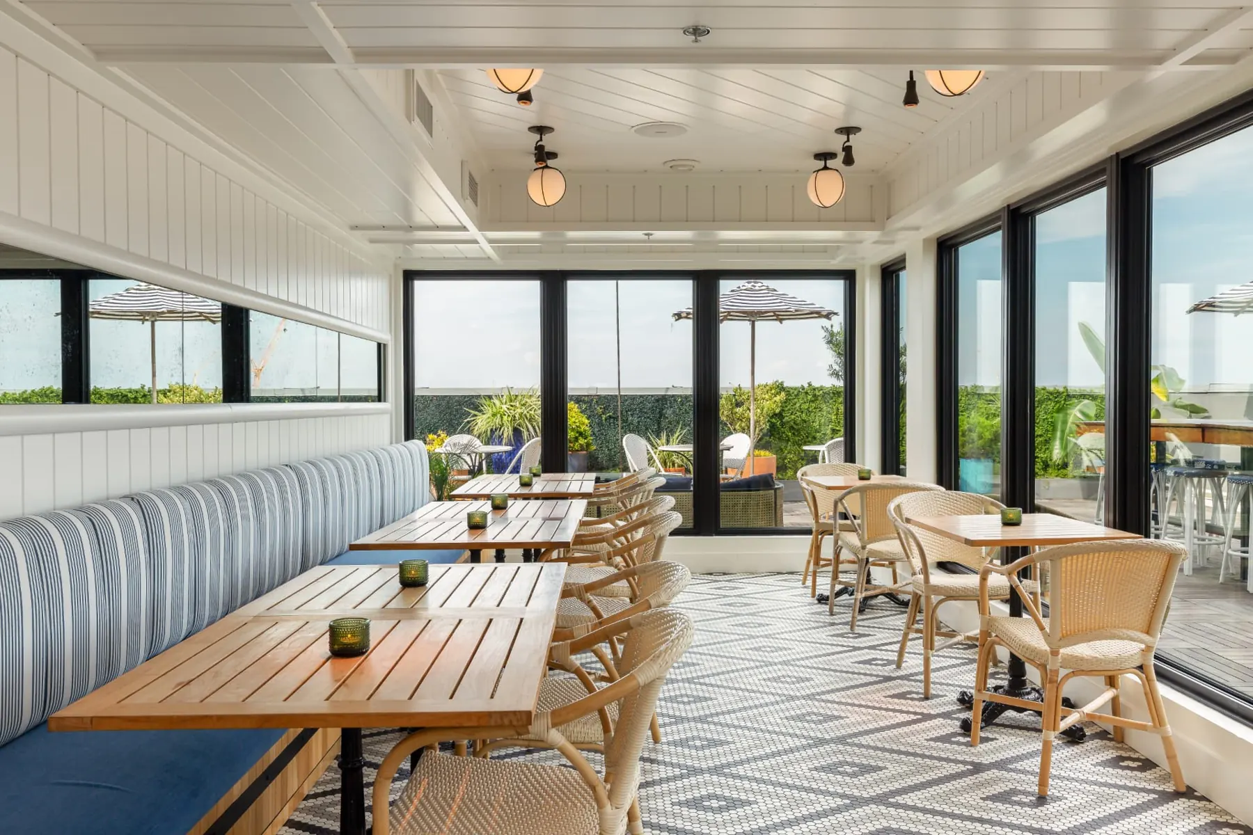 Pendant's indoor dining room with floor-to-ceiling windows opening onto the rooftop terrace